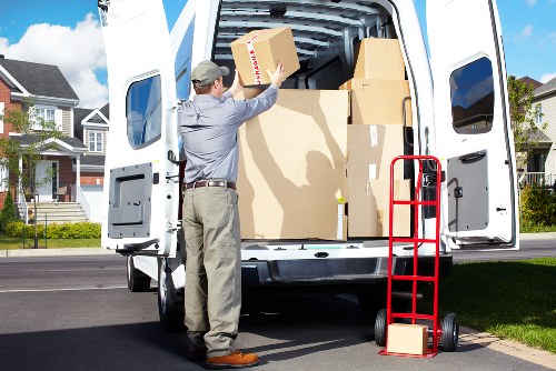 Professional movers carrying household items through a Greenwich property